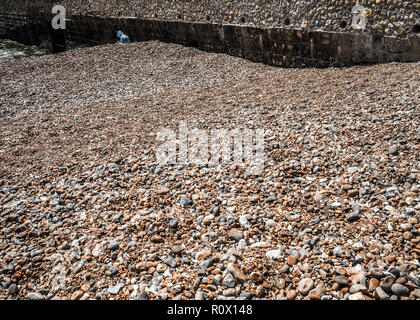 Einsame hooded Abbildung auf brighton Pebble Beach Stockfoto