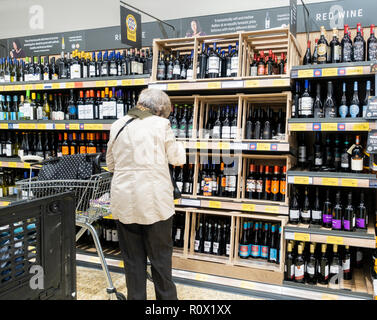 Ältere Frau kaufen Wein in Aldi Supermarkt. Großbritannien Stockfoto