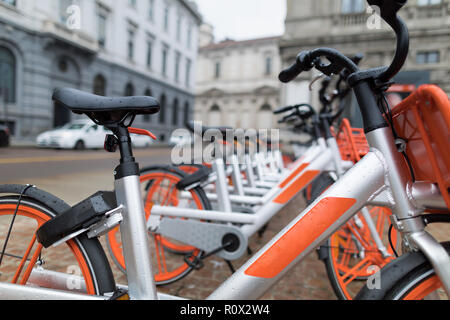 Fahrräder in einer Reihe auf dem Platz geparkt. Die orange und silber werden Fahrräder von Mobike, ein Unternehmen, das Service, die in der ganzen Stadt garantiert. Stockfoto