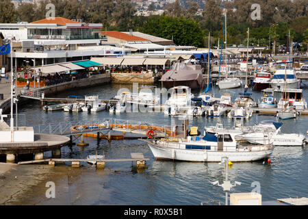 Boote in Paphos Hafen. Restaurants am Kai sind voll von Touristen. Zypern Oktober 2018 Stockfoto