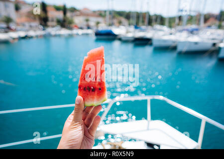 Woman's Hand hält ein Stück Wassermelone. Stockfoto