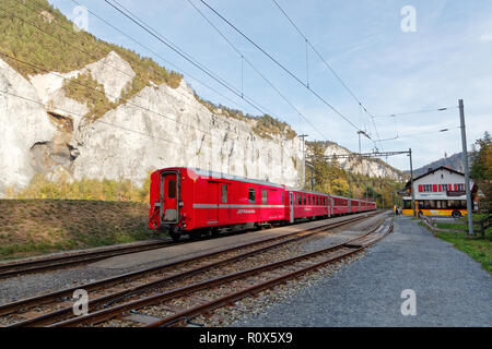 Versam-Safien, Ruinaulta, Schweiz - Oktober 16, 2018: Der Glacier Express Zug wartet am Bahnhof in sonnigen, herbstlichen Ruinaulta - Rheinschluc Stockfoto