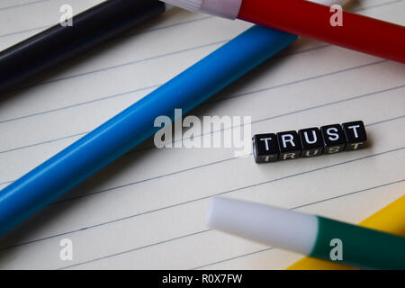 Vertrauen Nachricht auf hölzernen Blöcke geschrieben. Bildung und Motivation Konzepte. Kreuz verarbeitete Bild auf grünem Hintergrund Stockfoto