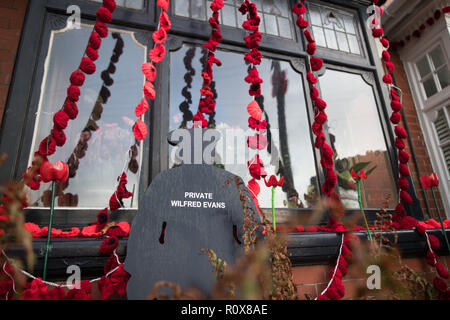 Ein Haus in der Station Road, Aldridge in Walsall, die sich in Poppy Straße als fast 100 Häuser verwandelt hat, dekoriert mit 24.000 roter Mohn und Silhouette Statuen von Soldaten, die Einheimischen, die ausgehalten und haben ihr Leben verloren in den Ersten Weltkrieg zu ehren. Stockfoto