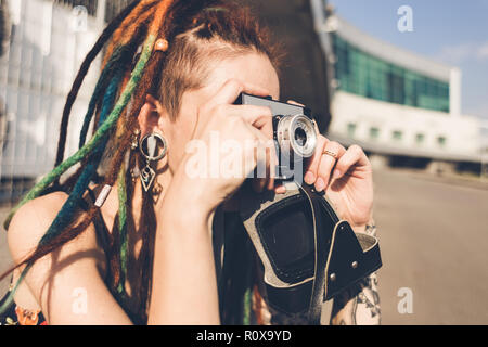 Junges Mädchen mit Tattoo und dreadlocks Bilder auf städtischen industriellen Hintergrund geschieht. Stockfoto