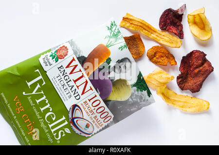 Paket der Tyrrells veg Kartoffelchips Hand geöffnet - Englisches Chips auf weißem Hintergrund - Pastinaken, Rote Bete und Karotten Chips mit Meersalz Stockfoto