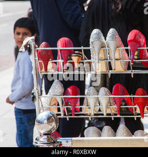 Indischer Junge auf der Straße neben der Frauen schuh Display rack Southall London Stockfoto