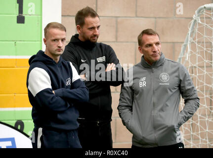 Celtic's Leigh Griffiths (links) und Manager Brendan Rodgers (rechts) mit Street Soccer Gründer und CEO David Duke (Mitte) sehen die Männer und Frauen Street Soccer Teams während einer speziellen Schulung an Lennoxtown, Glasgow. Stockfoto