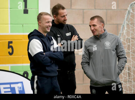 Celtic's Leigh Griffiths (links) und Manager Brendan Rodgers (rechts) mit Street Soccer Gründer und CEO David Duke (Mitte) sehen die Männer und Frauen Street Soccer Teams während einer speziellen Schulung an Lennoxtown, Glasgow. Stockfoto