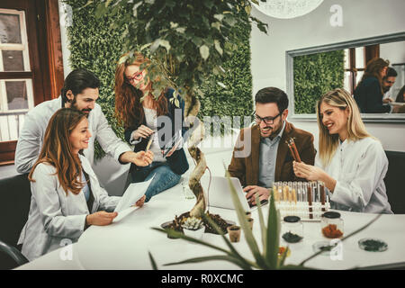 Clevere progressive junge Ingenieure arbeiten an digitalen Tablet auf einer ökologischen Bauvorhaben im Büro, reden über einige grüne Projekt. Stockfoto