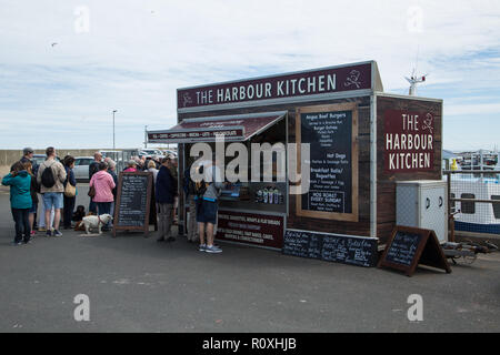 Die Mitarbeiter und Kunden kaufen Essen im Hafen Küche in Nevsehir Hafen, Northumberland, Großbritannien Stockfoto