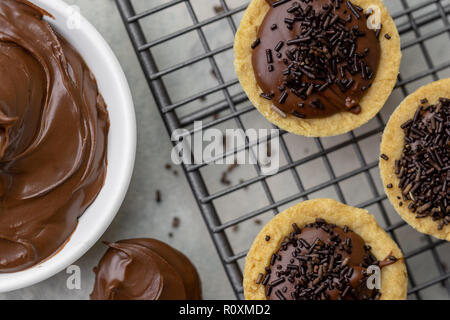 Nutella Törtchen mit Schokolade Streusel auf einem Backblech Schuß von oben mit Nutella auf der Seite Stockfoto