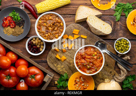 Zwei Winter warmer Eintöpfe durch Inhaltsstoffe overhead Shot umgeben: butternut squash Eintopf und Chili con Carne Stockfoto