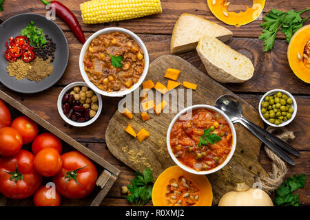 Zwei Winter warmer Eintöpfe durch Inhaltsstoffe overhead Shot umgeben: butternut squash Eintopf und Chili con Carne Stockfoto