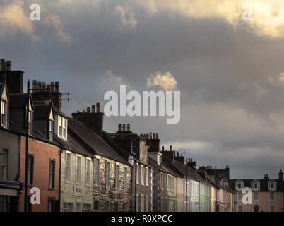 Winterlichen Himmel über eine Reihe von bemalten Reihenhäuser in Kirkcudbright, Dumfries und Galloway, SW Schottland Stockfoto