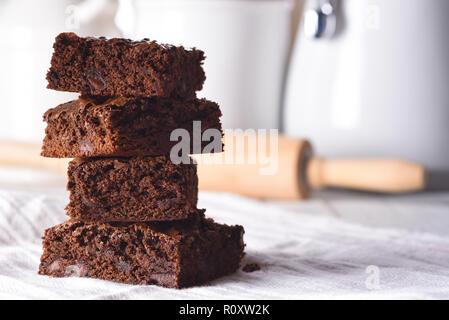 Nahaufnahme von einem Teller mit frischen hausgemachten Brownies auf einem weißen Handtuch und Holz kithcen Tabelle, mit Kanistern und Rolling Pin im Hintergrund. Stockfoto