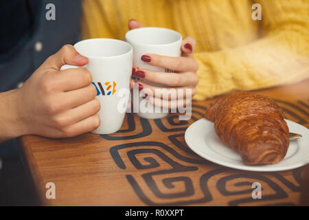 Junges Paar auf Datum halten sich an den Händen und Tassen mit Kaffee. Selektive konzentrieren. Stockfoto