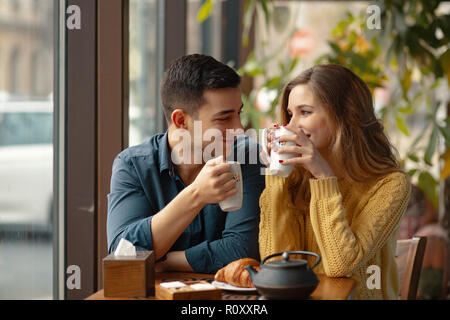 Junge attraktive Paar auf Datum im Coffee Shop ein Gespräch und die Zeit miteinander verbracht. Stockfoto