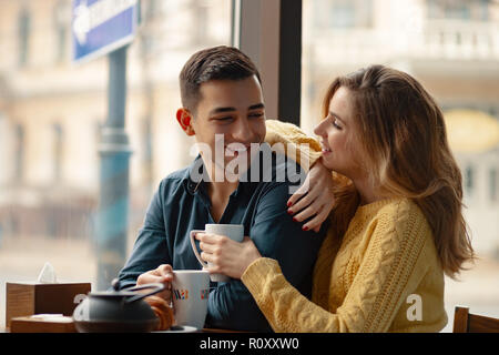 Junge attraktive Paar auf Datum im Coffee Shop ein Gespräch und die Zeit miteinander verbracht. Stockfoto