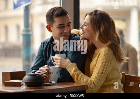 Junge attraktive Paar auf Datum im Coffee Shop ein Gespräch und die Zeit miteinander verbracht. Stockfoto