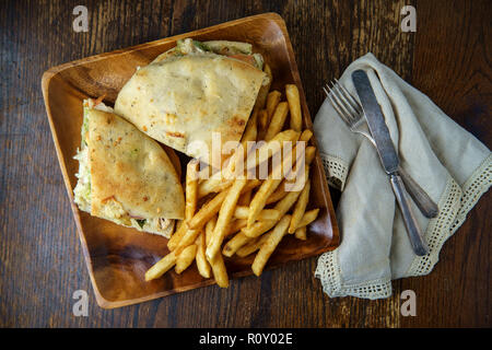 Gegrilltes Hähnchen Panini mit frischen knusprigen Steak frites auf rustikalen Küche aus Holz Tisch Stockfoto