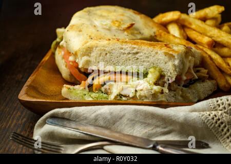 Gegrilltes Hähnchen Panini mit frischen knusprigen Steak frites auf rustikalen Küche aus Holz Tisch Stockfoto