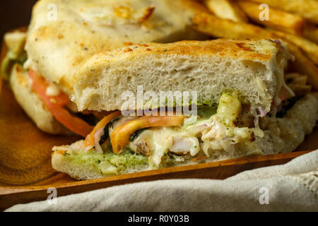 Gegrilltes Hähnchen Panini mit frischen knusprigen Steak frites auf rustikalen Küche aus Holz Tisch Stockfoto