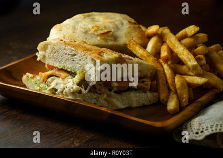 Gegrilltes Hähnchen Panini mit frischen knusprigen Steak frites auf rustikalen Küche aus Holz Tisch Stockfoto