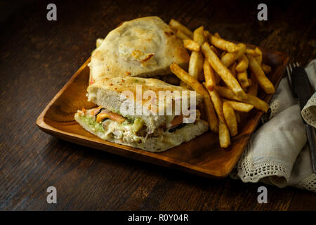 Gegrilltes Hähnchen Panini mit frischen knusprigen Steak frites auf rustikalen Küche aus Holz Tisch Stockfoto