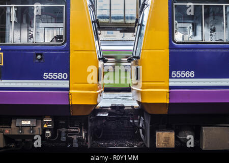 2 Northern Rail pacer Züge in Preston Nase an Nase, während ein anderer Zug fährt hinter Stockfoto
