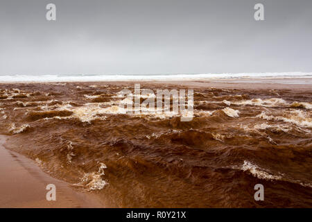 Der Abfluss von Sandwood Loch in der Flut Bedingungen über den Strand von Sandwood Bay, Sutherland, Schottland, Großbritannien, mit dem Wasser schwer befleckt durch Torf. Stockfoto