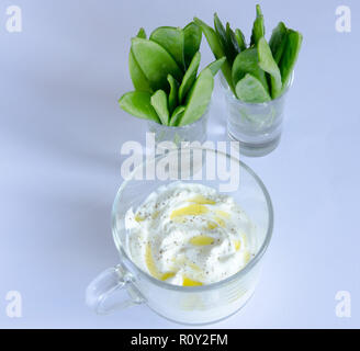 Schnee Erbsen in einem kleinen Glas mit Dip auf der Vorderseite auf weißem Hintergrund Stockfoto