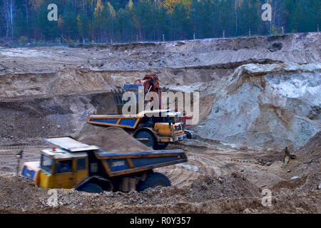 Bagger laden von Sand, Erz auf dem Dump Truck. Die großen Bergbau Dump Truck ist Bergbaumaschinen, oder Bergbau Sand von open-pit Stockfoto