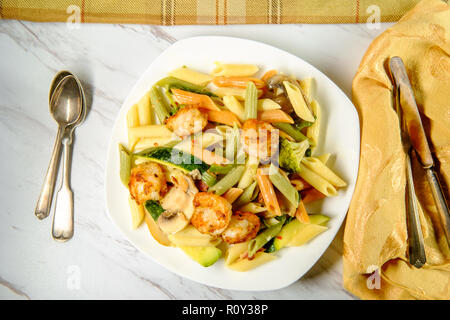 Garnelen Primavera mit Trikolore Penne in einer Weißweinsauce Stockfoto