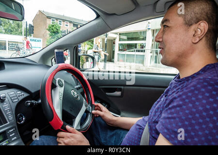 London England, Großbritannien, Lambeth South Bank, uber driver driving, Auto, innen, Lenkrad, Asian man men Male, right-Hand drive System, Toyota Prius, wo Stockfoto