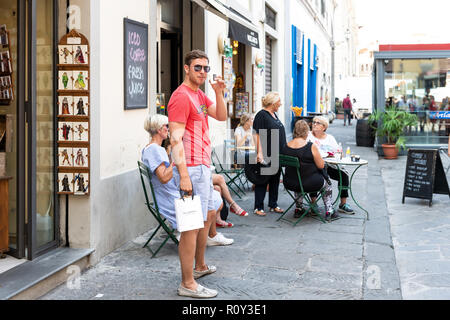 Florenz, Italien - 30 August, 2018: Der junge Italiener in Sonnenbrille bei Firenze Street Cafe, Restaurant in T-Shirt, Shorts, holding Kunststoff coff Stockfoto