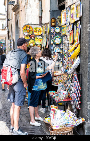 Orvieto, Italien - 3. September 2018: Senior, alte Paar, Mann, Frau, Einkaufsmöglichkeiten für Souvenirs in der kleinen italienischen Stadt, Stadt von Street Hersteller, Verkäufer, Halten Stockfoto