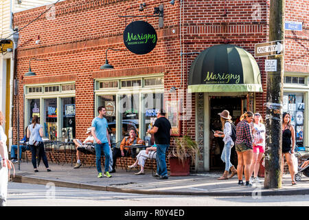 New Orleans, USA - 22. April 2018: Frenchmen Street in Louisiana, Stadt, Stadt, Gebäude, Menschen sitzen stehend von Marigny Brasserie und Bar res Stockfoto