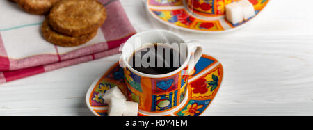 Bunte heiße Tasse Espresso mit Cookies und Zucker. Weiße Holz- Hintergrund. Nähe zu sehen. Facebook Abdeckung Format Stockfoto