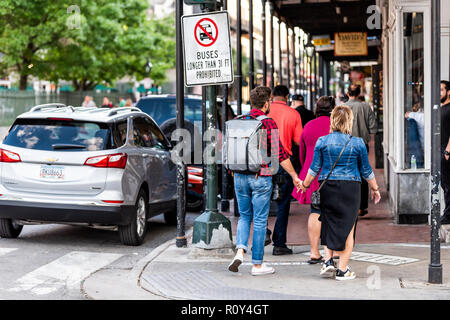 New Orleans, USA - 22. April 2018: Decatur Street in Louisiana berühmten Stadt, Stadt, in Abend, Menschenmenge, zurück von Paar romantische Hände halten w Stockfoto