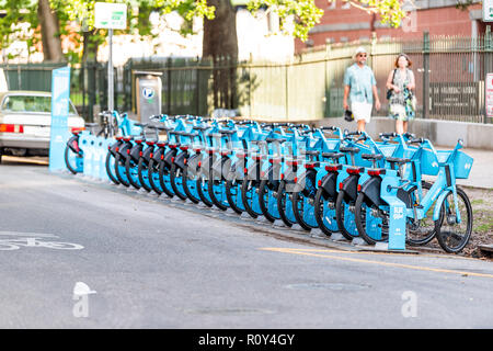 New Orleans, USA - 22. April 2018: Decatur Kaserne Straße in Louisiana berühmten Stadt, Stadt, im Sonnenuntergang am Abend, Menschen wandern, Reihe mit vielen blauen Fahrrad Stockfoto