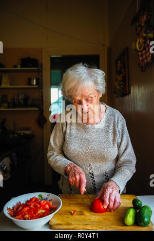 Ältere Frau Gemüse vorbereiten für einen Salat. Stockfoto