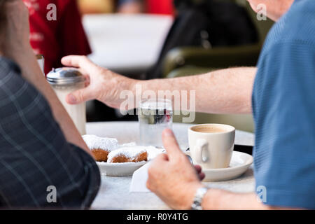 New Orleans, USA berühmten Cafe Restaurant in Louisiana Altstadt Stadt mit älteren Menschen an Tischen essen beliebte Gebäck beignets Donut sitzen Stockfoto