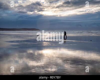 Woolacombe Devon, Großbritannien. 7. Nov 2018. Wanderer genießen Sie den Strand wie Gewitterwolken über den Atlantischen Ozean als eine Reihe von schweren Duschen mit starken Winden Teig dem Westen des Landes in der wechselhaften Herbst Wetter versammeln. Credit: Julian Eales/Alamy Leben Nachrichten. Stockfoto