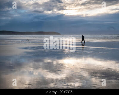 Woolacombe Devon, Großbritannien. 7. Nov 2018. Wanderer genießen Sie den Strand wie Gewitterwolken über den Atlantischen Ozean als eine Reihe von schweren Duschen mit starken Winden Teig dem Westen des Landes in der wechselhaften Herbst Wetter versammeln. Credit: Julian Eales/Alamy Leben Nachrichten. Stockfoto