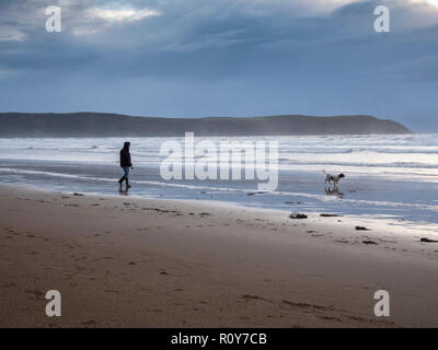 Woolacombe Devon, Großbritannien. 7. Nov 2018. Wanderer genießen Sie den Strand wie Gewitterwolken über den Atlantischen Ozean als eine Reihe von schweren Duschen mit starken Winden Teig dem Westen des Landes in der wechselhaften Herbst Wetter versammeln. Credit: Julian Eales/Alamy Leben Nachrichten. Stockfoto