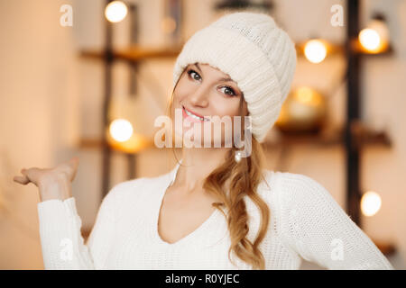 Wunderschöne Frau in weißen Schirmmütze und Ohrringe über bokeh Hintergrund. Stockfoto