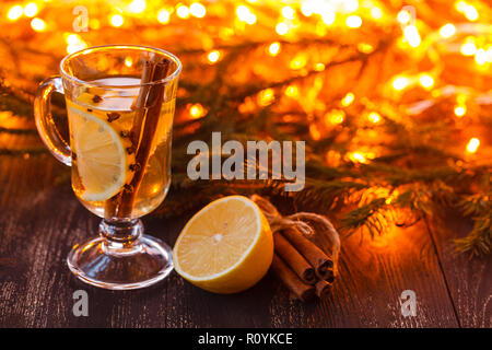 Easonal und Feiertage Konzept. Weihnachten und im Herbst Thema. Ein Glas Glühwein auf einem rustikalen Holztisch. Selektiver Fokus Stockfoto