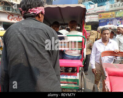 Touristische auf Rikschas machen sich durch die überfüllten Markt Straßen der Altstadt von Delhi, Indien. Stockfoto