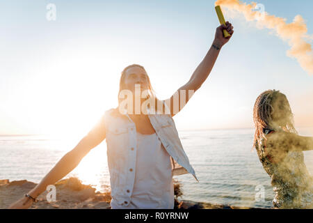 Mann mit langen blonden Haaren halten bunte Brandbombe viel Spaß Stockfoto